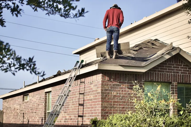 Professional roofer working on a residential roof in West Milton